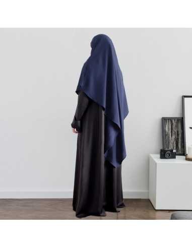 Une femme musulmane vetu d'une abaya noir porte un khimar bleu foncé 